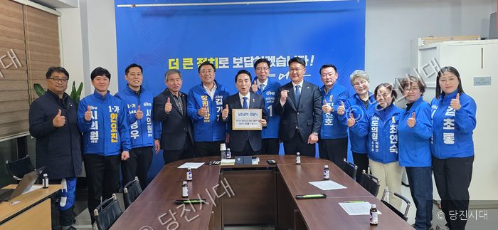 정치인과 박수현 씨 등이 회의실에서 당진 공약 전달식을 진행하고 있다.