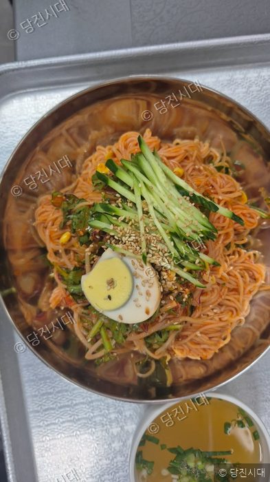 식당에서 매콤하게 버무려진 비빔국수를 그릇에 담아 제공하고 있다.