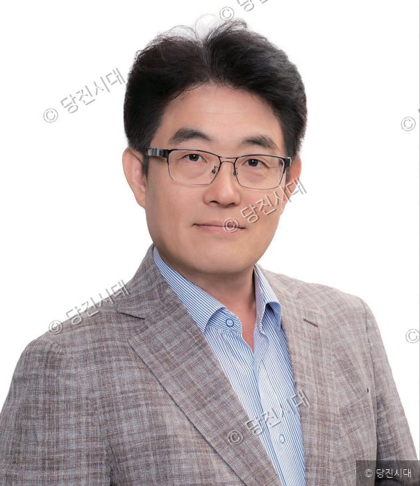김석붕 씨가 정장 차림으로 미소를 지으며 카메라를 바라보고 있다.