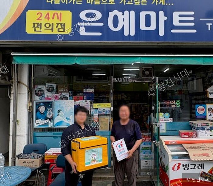 마트 관계자가 번개탄 안전 보관함을 전달받고 있다.