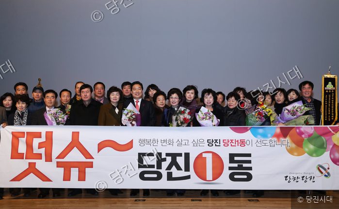 당진1동 관계자들이 새마을지도자 대회에서 현수막을 들고 기념촬영을 하고 있다.