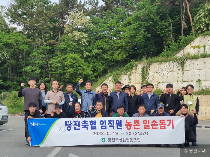당진축협 임직원들이 농촌 일손돕기 활동을 기념하며 단체 사진을 찍고 있다.