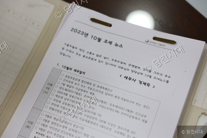 세무법인의 2023년 10월 조세 뉴스 문서가 놓여 있다.