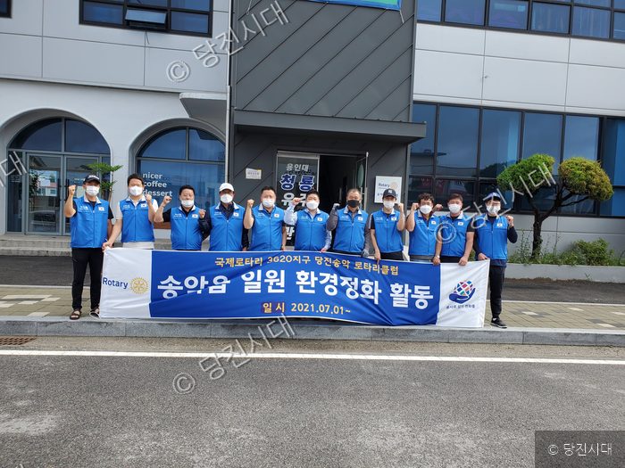 로타리클럽 회원들이 환경정화 활동을 기념하며 포즈를 취하고 있다.