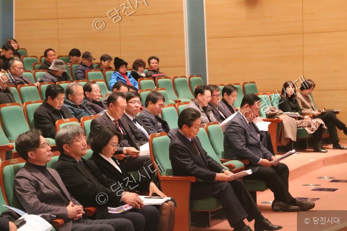참석자들이 강당 좌석에 앉아 토론회 자료를 살펴보고 있다.