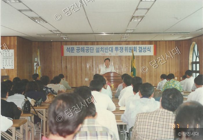 사람들이 실내에서 석문공해공단설치반대 투쟁위원회 결성식을 개최하고 있다.