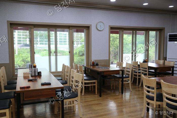 식당 내부의 테이블과 의자가 정돈되어 있다.