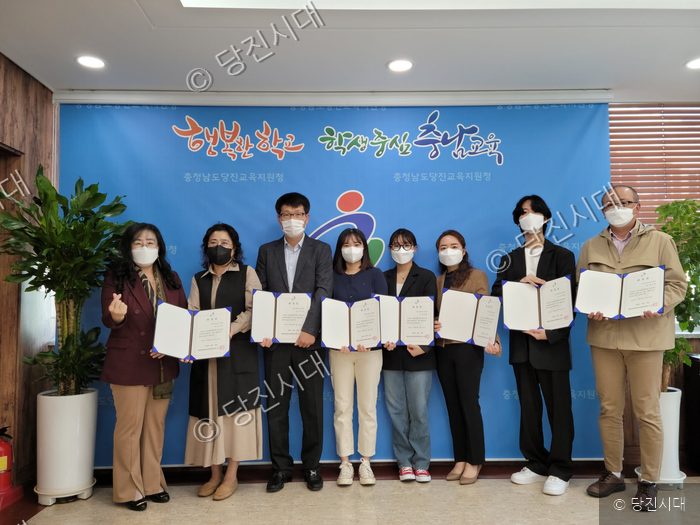참석자들이 라온 배움교실 지원단 위촉식에서 위촉장을 들고 기념 촬영을 하고 있다.