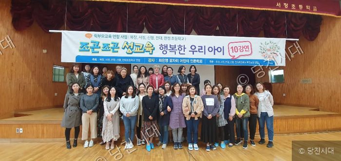 초등학교 학부모들이 모여 성교육 강연 기념 사진을 찍고 있다.