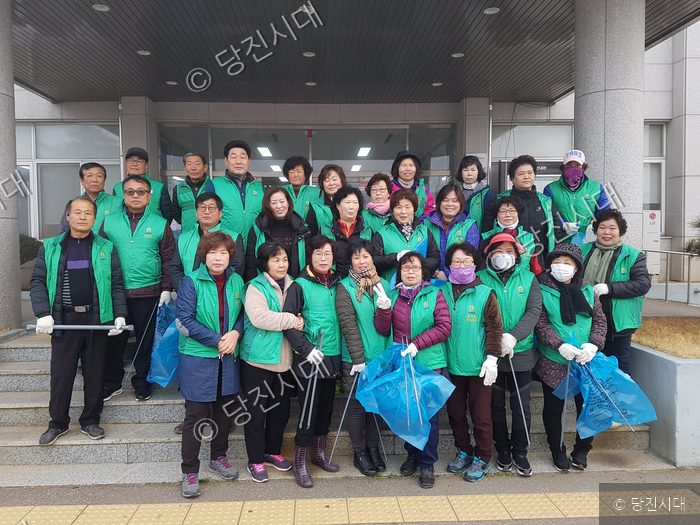 합덕 지역 주민들이 새마을 운동 조끼를 입고 단체로 모여 포즈를 취하고 있다.