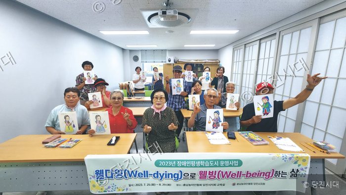 어르신들이 웰다잉 교육에서 직접 색칠한 그림을 들어 보이고 있다.