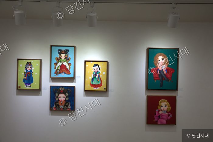 갤러리 벽면에 다양한 베이비돌 회화 작품들이 전시되어 있다.