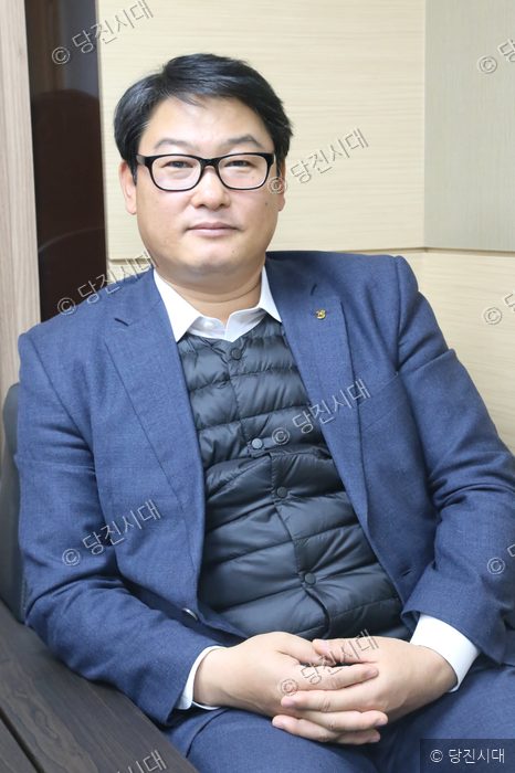 구본관 송산농협 상무가 인터뷰를 위해 앉아 포즈를 취하고 있다.