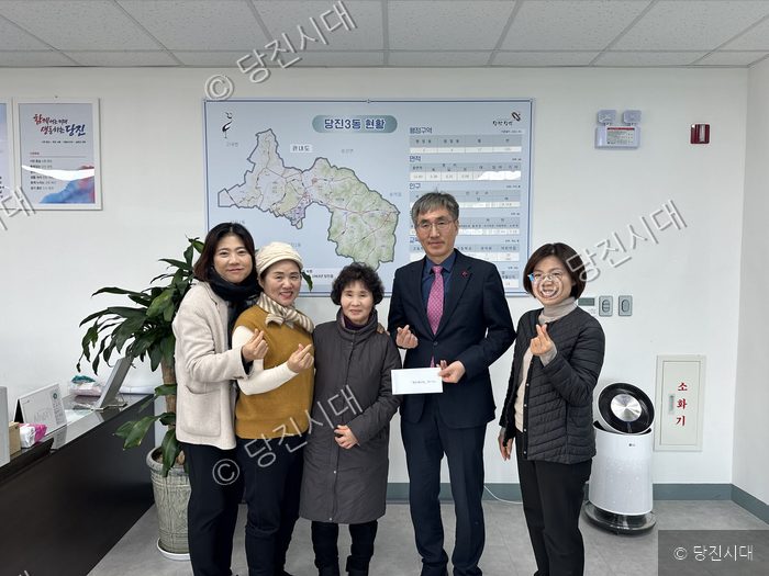 당진3동 원당8통 부녀회 관계자들이 관계자에게 성금을 전달하고 있다.