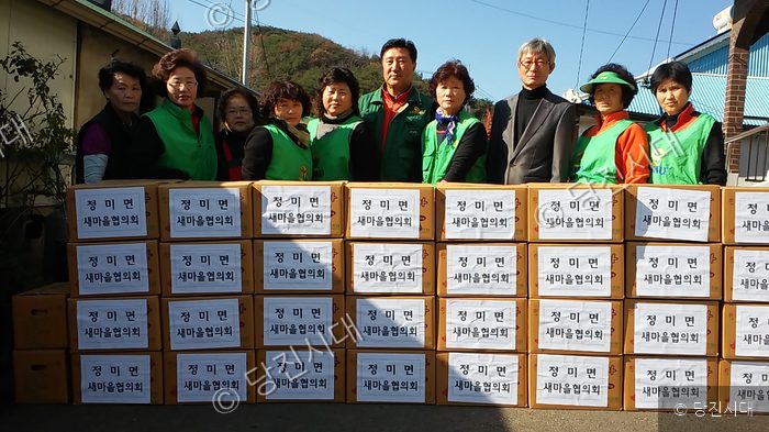 봉사자들이 상자 앞에 서서 포즈를 취하고 있다.
