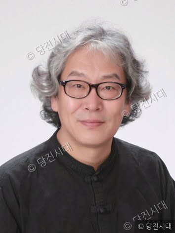 안경을 쓴 오융진 씨가 정면을 바라보며 미소 짓고 있다.