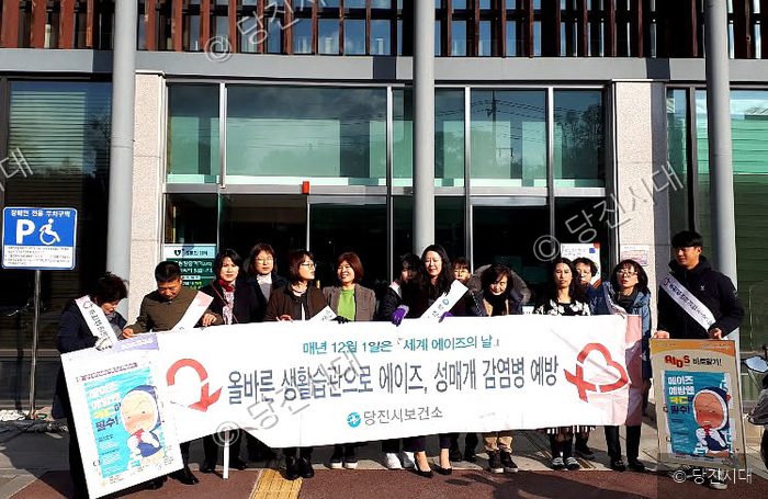 당진시보건소 직원들이 에이즈 예방 캠페인 현수막을 들고 서 있다.