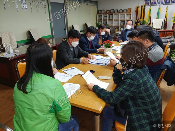 사람들이 회의실에 모여 자료를 검토하고 있다.