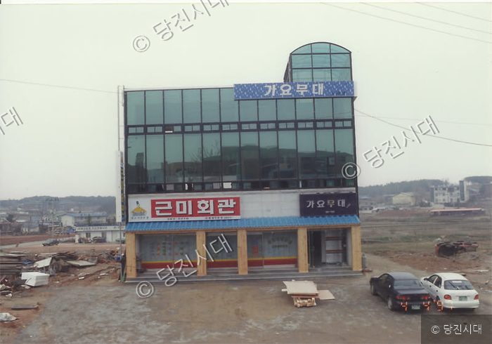 건물 전면에 '가요무대'와 '근미회관' 간판이 달린 건물이 서 있다.