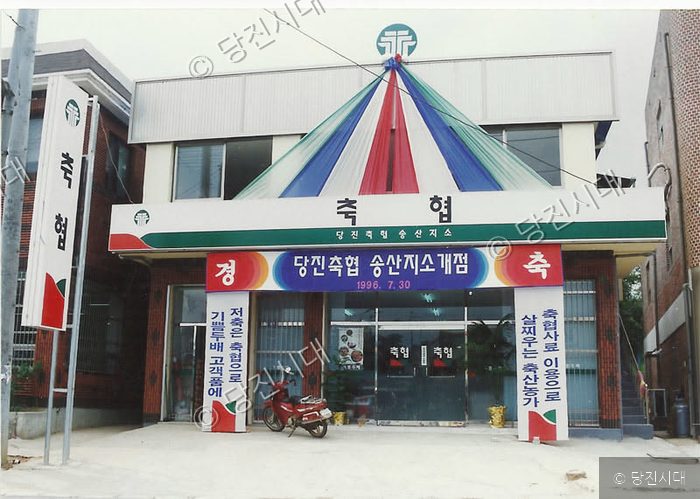 당진축협 송산지소가 개점하여 건물 외관이 행사를 위해 꾸며져 있다.