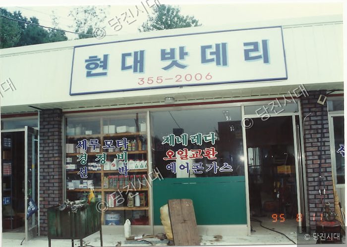 현대밧데리 간판이 달린 자동차 정비업소 전경이다.