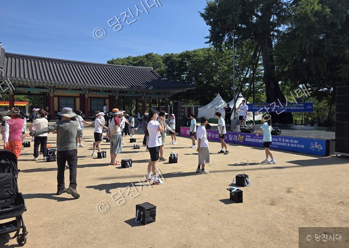 시민들이 야외에서 체육대회 붐 조성을 위한 스트레칭을 하고 있다.