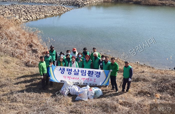 당진2동 주민들이 하천 주변에서 환경정화 활동을 마친 뒤 기념촬영을 하고 있다.