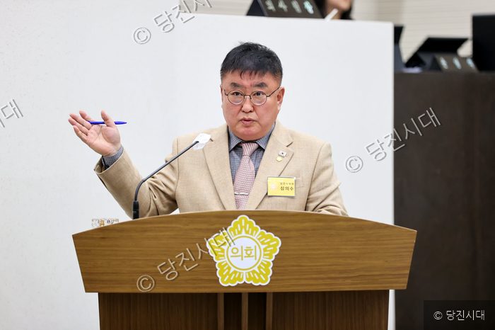 한 의원이 의회 단상에서 발언하며 제스처를 취하고 있다.