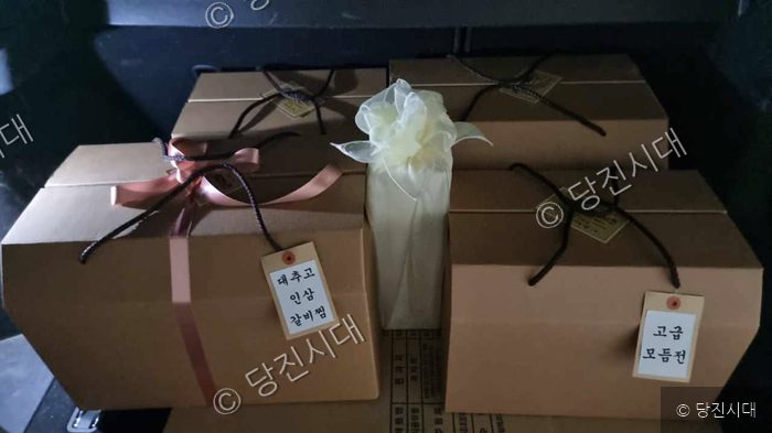 정성스럽게 포장된 명절 선물용 음식 상자들이 놓여 있다.