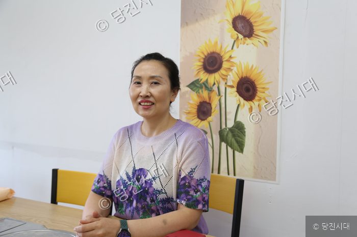 국수한그릇 구자순 대표가 식당에서 환하게 미소 짓고 있다.
