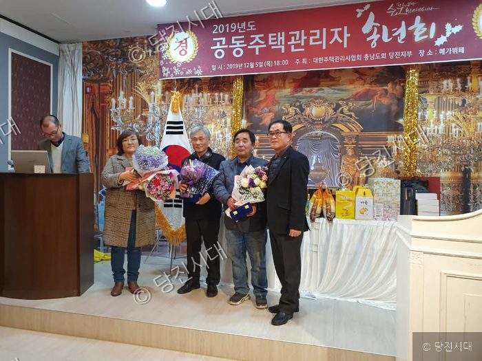 공동주택 관리자들이 송년회 행사를 기념하여 기념촬영을 하고 있다.