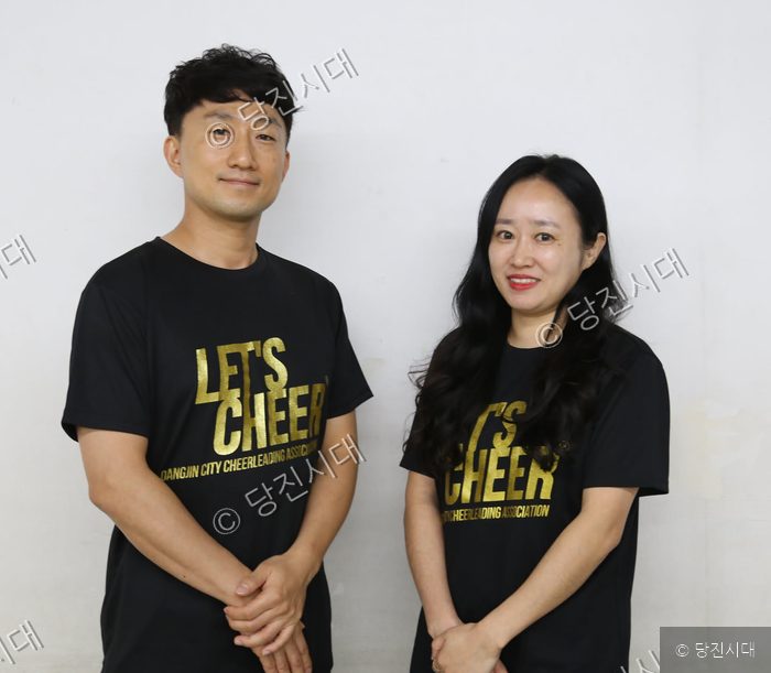 당진시치어리딩협회 회장과 부회장이 검은색 단체 티셔츠를 입고 포즈를 취하고 있다.