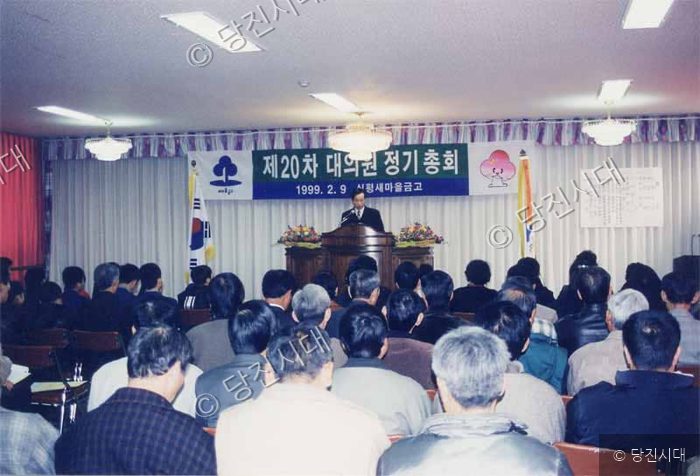 실내에서 많은 사람들이 참석한 가운데 정기총회가 개최되고 있다.