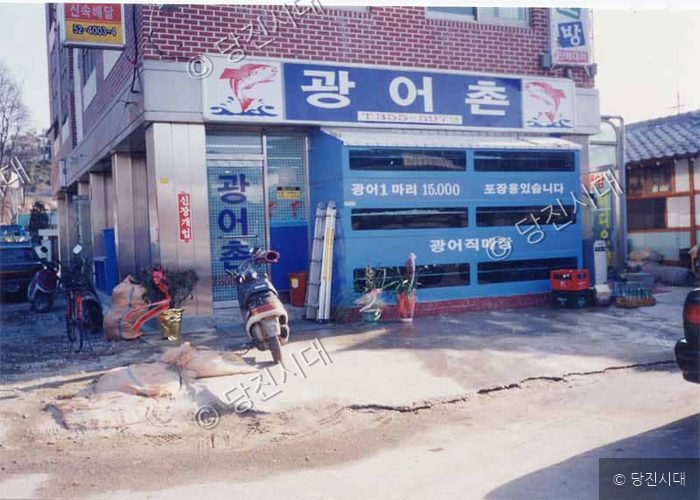 도심 골목에 위치한 '광어촌' 횟집 건물 전경을 보여주고 있다.