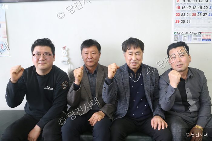 지역 낙농인 네 명이 주먹을 쥐고 파이팅을 하고 있다.