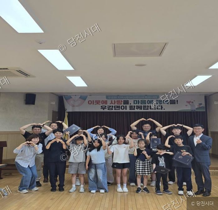 우강면 지역사회보장협의체가 초등학생들에게 희망장학금을 전달하며 기념 촬영을 하고 있다.