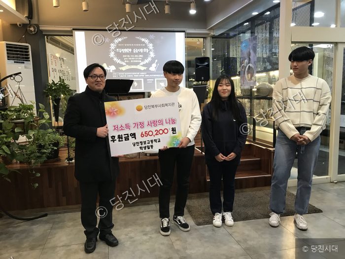 당진정보고 학생들이 당진북부사회복지관에 저소득 가정 사랑의 나눔 성금을 전달하고 있다.