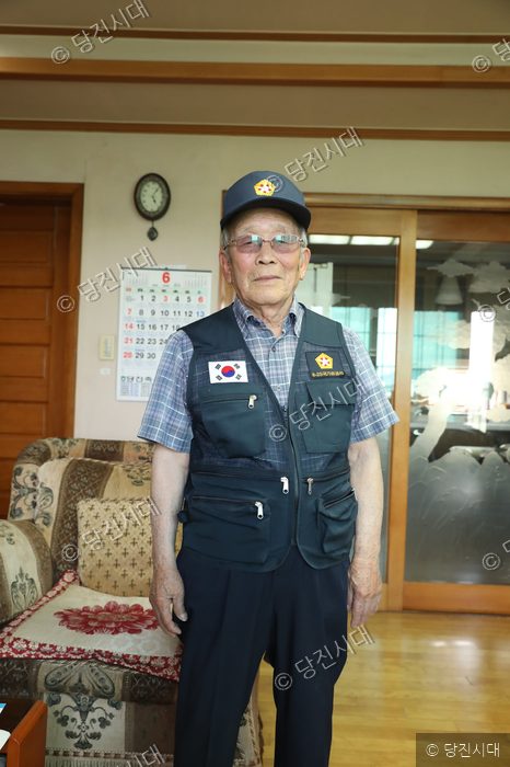 박윤식 옹이 모자를 쓰고 서 있다.