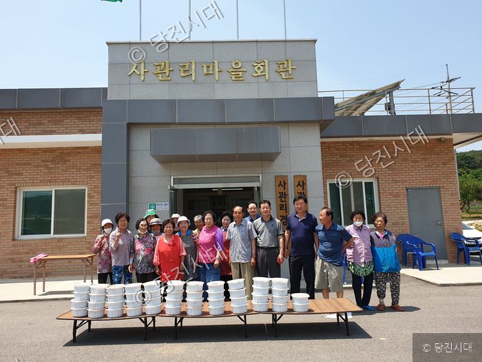 사관리 마을회관 앞에서 주민들이 새마을 운동 활동을 기념하고 있다.