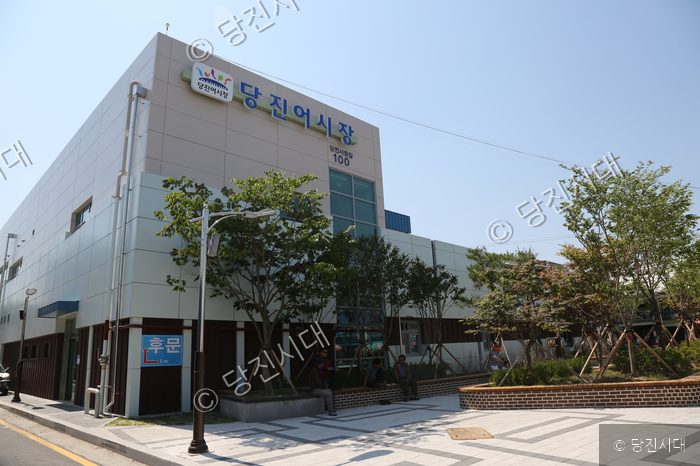 당진어시장 건물의 외부 모습과 주변 풍경이 보인다.