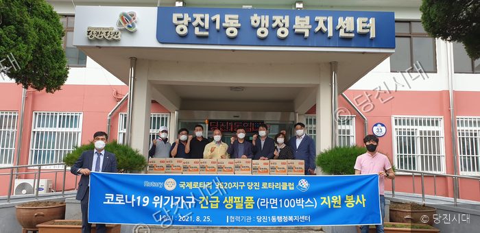 당진로타리클럽이 행정복지센터에 라면 100박스를 기탁하고 기념사진을 찍고 있다.