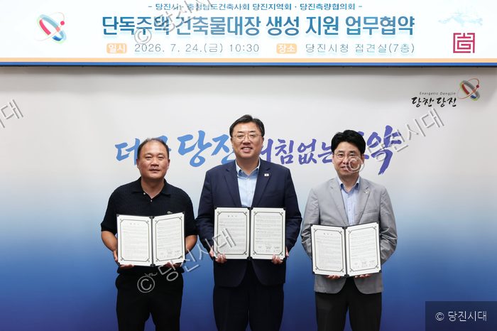 당진시청에서 관계자들이 단독주택 건축물대장 생성 지원을 위한 업무협약을 체결하고 기념 촬영을 하고 있다.