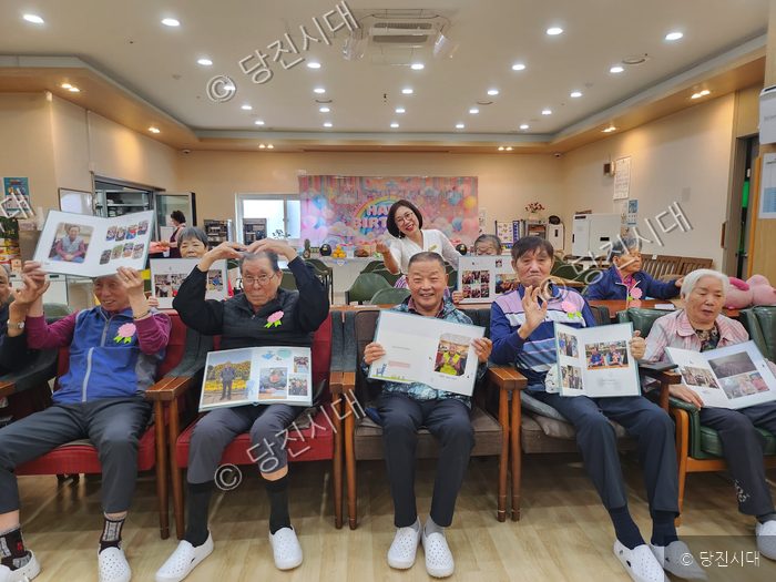 온누리주야간센터에서 어버이날을 맞아 어르신들에게 개별 제작한 앨범을 전달하고 있다.