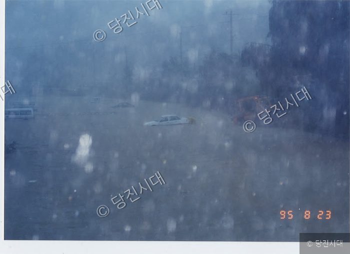 집중호우로 인해 도로가 침수되어 차량들이 물에 잠겨 있다.