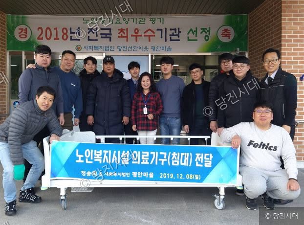 청송회 회원들이 평안마을에 노인복지시설 의료기구를 전달하고 기념촬영을 하고 있다.