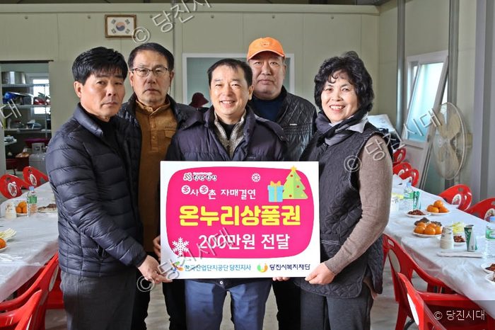 다섯 명의 사람들이 온누리상품권 전달식을 하며 기념 촬영을 하고 있다.