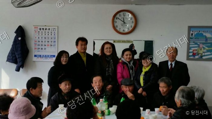 우강노인대학 행사에서 어르신들과 관계자들이 함께 기념촬영을 하고 있다.