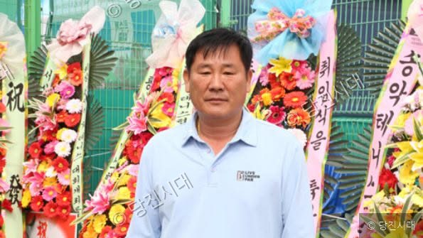 김응규 테니스협회장이 화환이 놓인 곳에서 포즈를 취하고 있다.
