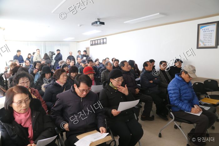 주민들이 회의실에 모여 앉아 자료를 살펴보고 있다.