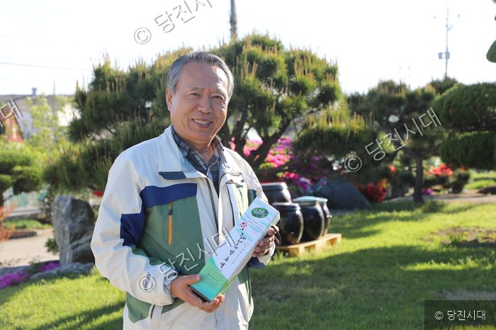 한성희 사장이 해나루발효식품 제품 상자를 들고 미소 짓고 있다.